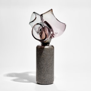 abstract floral sculpture with column of dark grey stone base with transparent purple pink cut bubbles on top