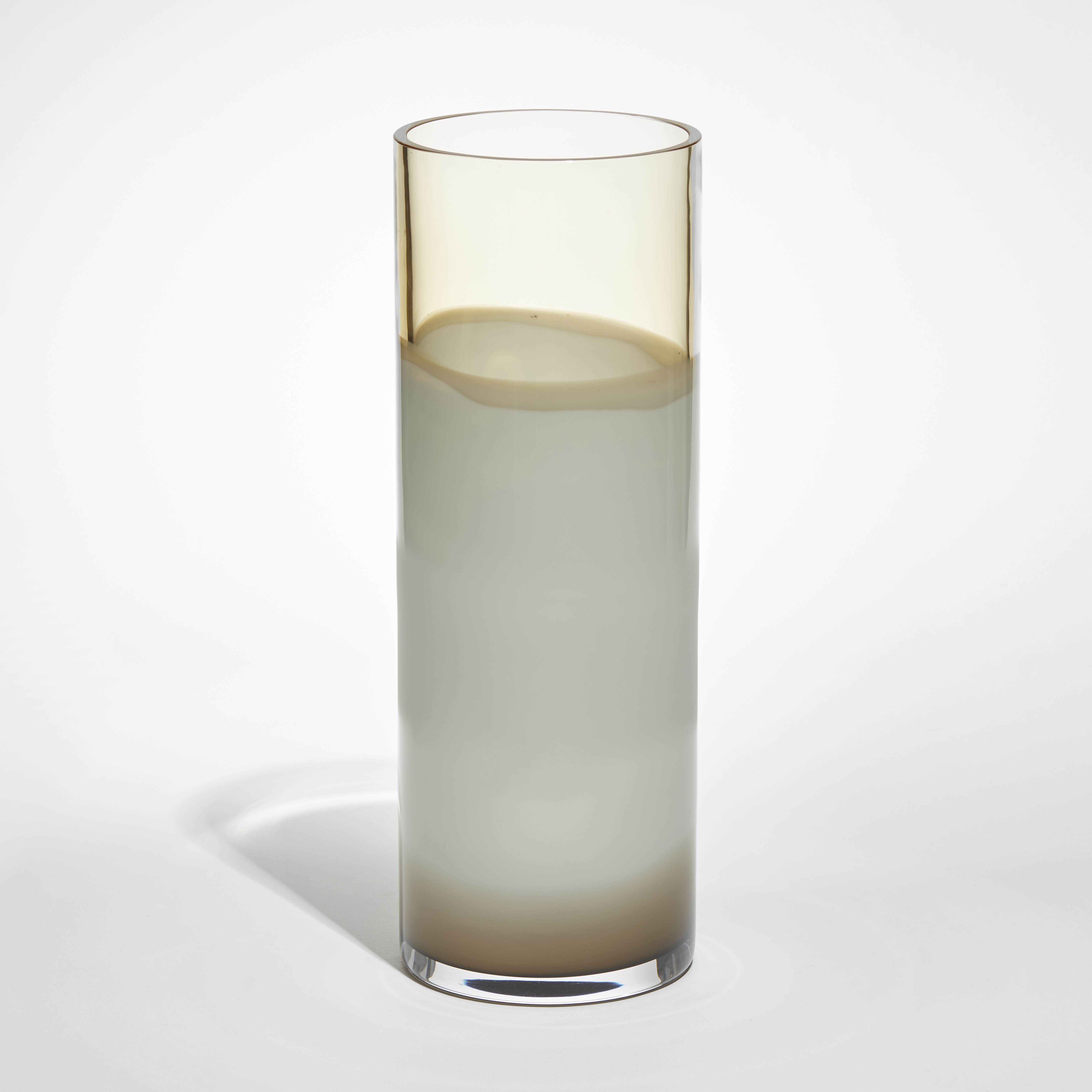 smooth cylindrical vase in abstract uneven bands of transparent amber opaque white and brown hand made from glass