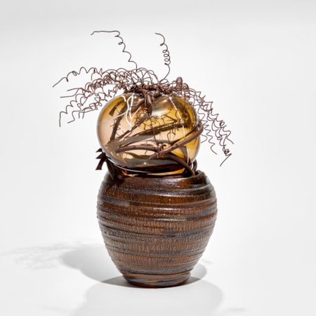 brown ridged ceramic urn containing a bursting forth bubble of amber glass bound in copper with copper wire cork screw hair