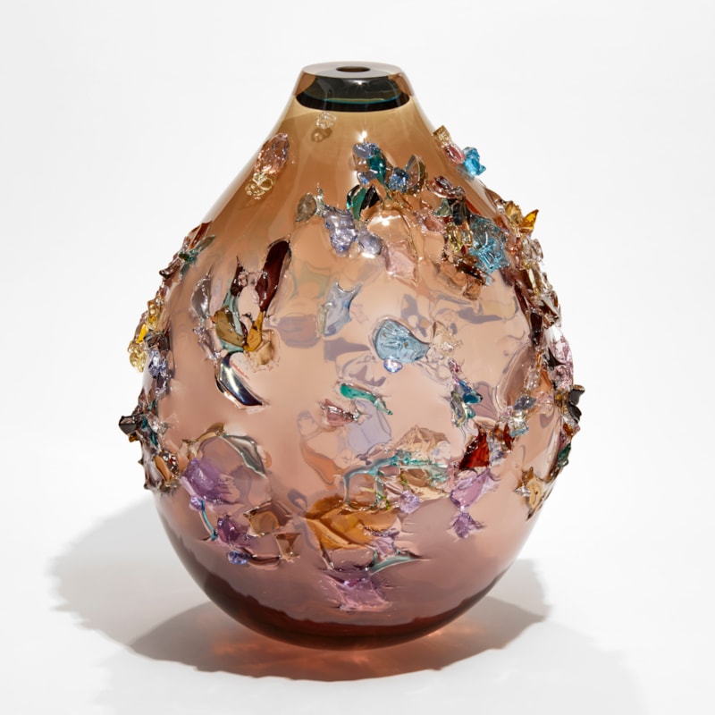 pink fading to brown rounded teardrop vessel covered in multicoloured organic shards made from blown glass
