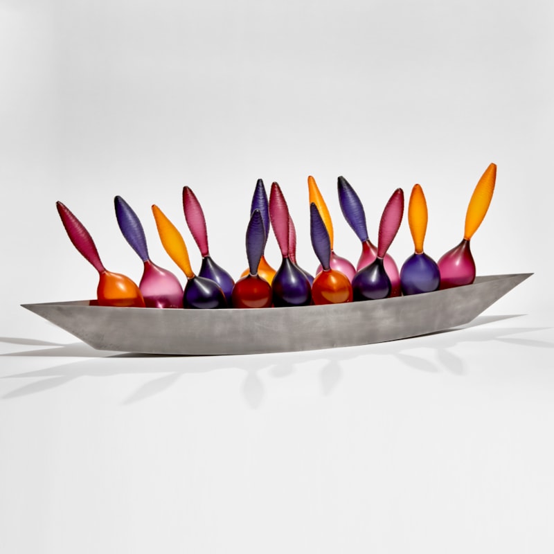 rich purple raspberry and orange glass amphora shaped bottles cradled in a steel boat shaped hull