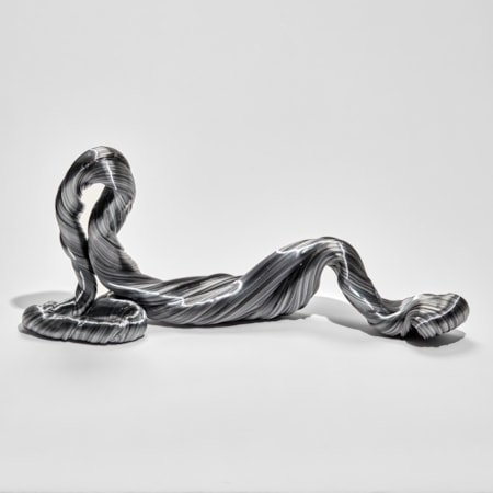 grey twisted and looping ridged sculpture mimicking an unravelling piece of wool hand made from glass