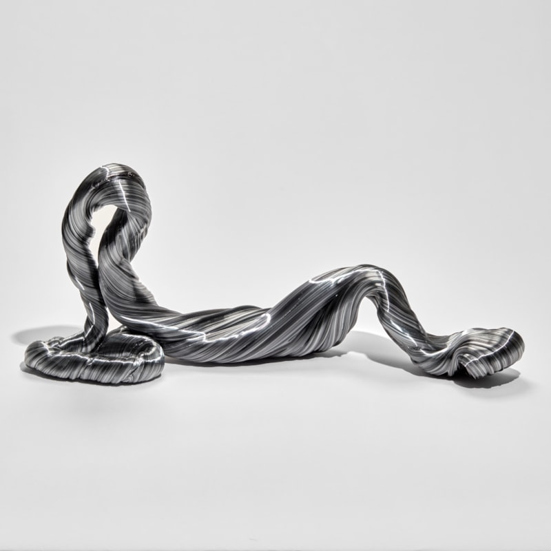 grey twisted and looping ridged sculpture mimicking an unravelling piece of wool hand made from glass