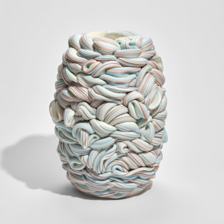 white blue and pink barrel shaped vessel that looks like a bobbin of wool hand made from parian porcelain