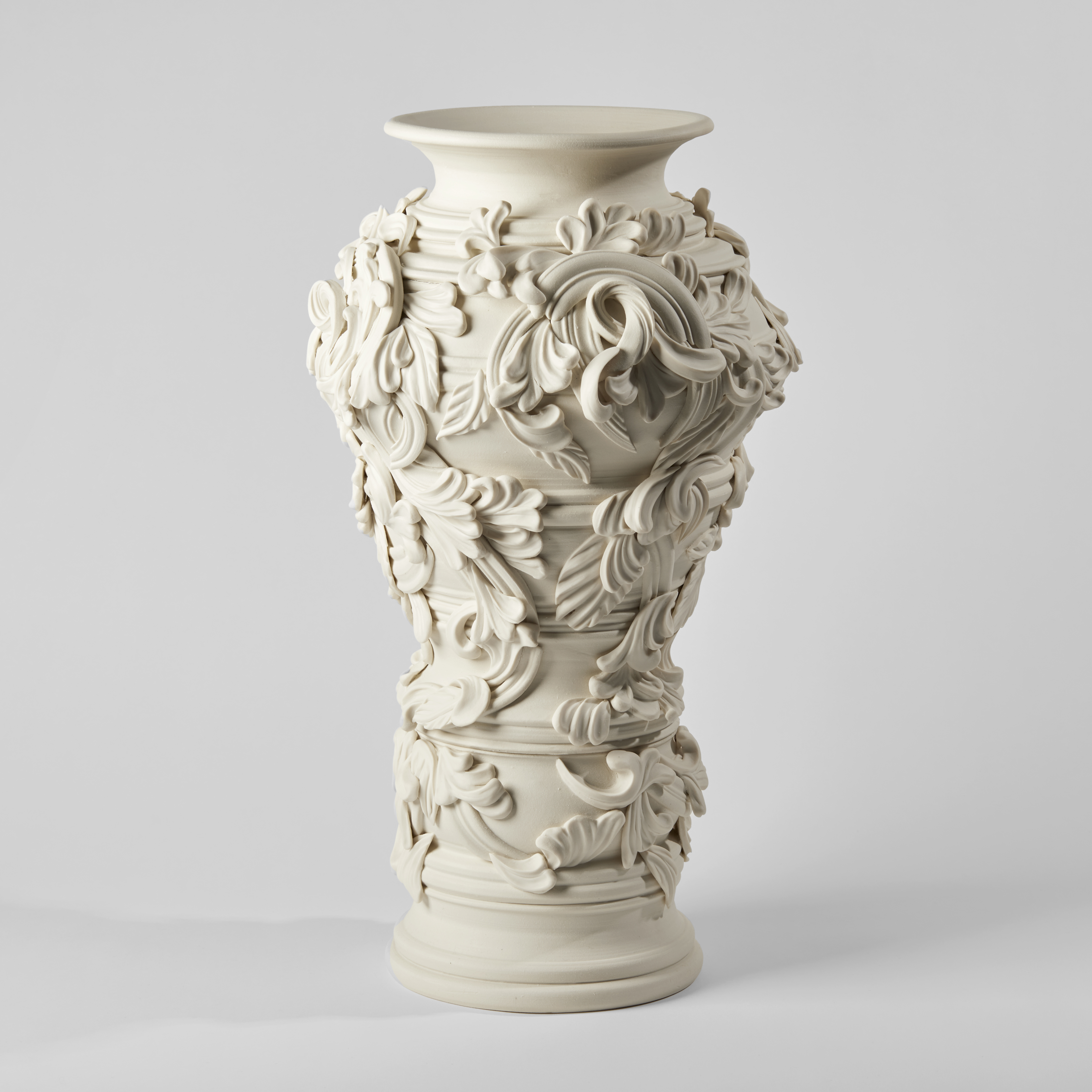 undulating column vase handmade from porcelain covered in organic flourishes and abstract leaves with rounded opening at the top