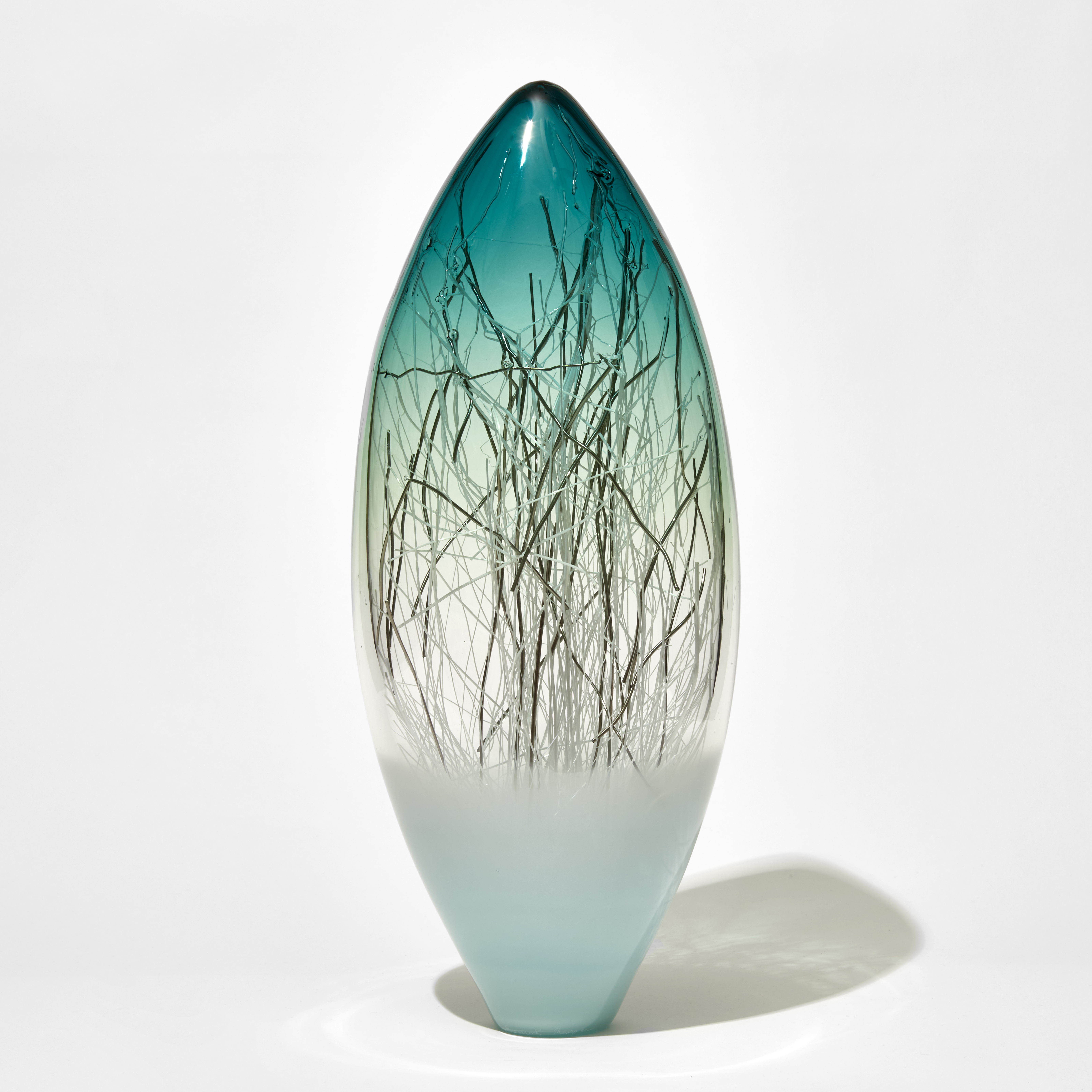 tall void with soft blue base fading to a clear middle with jade sea green topped containing thin strands of white and platinum hand made from glass