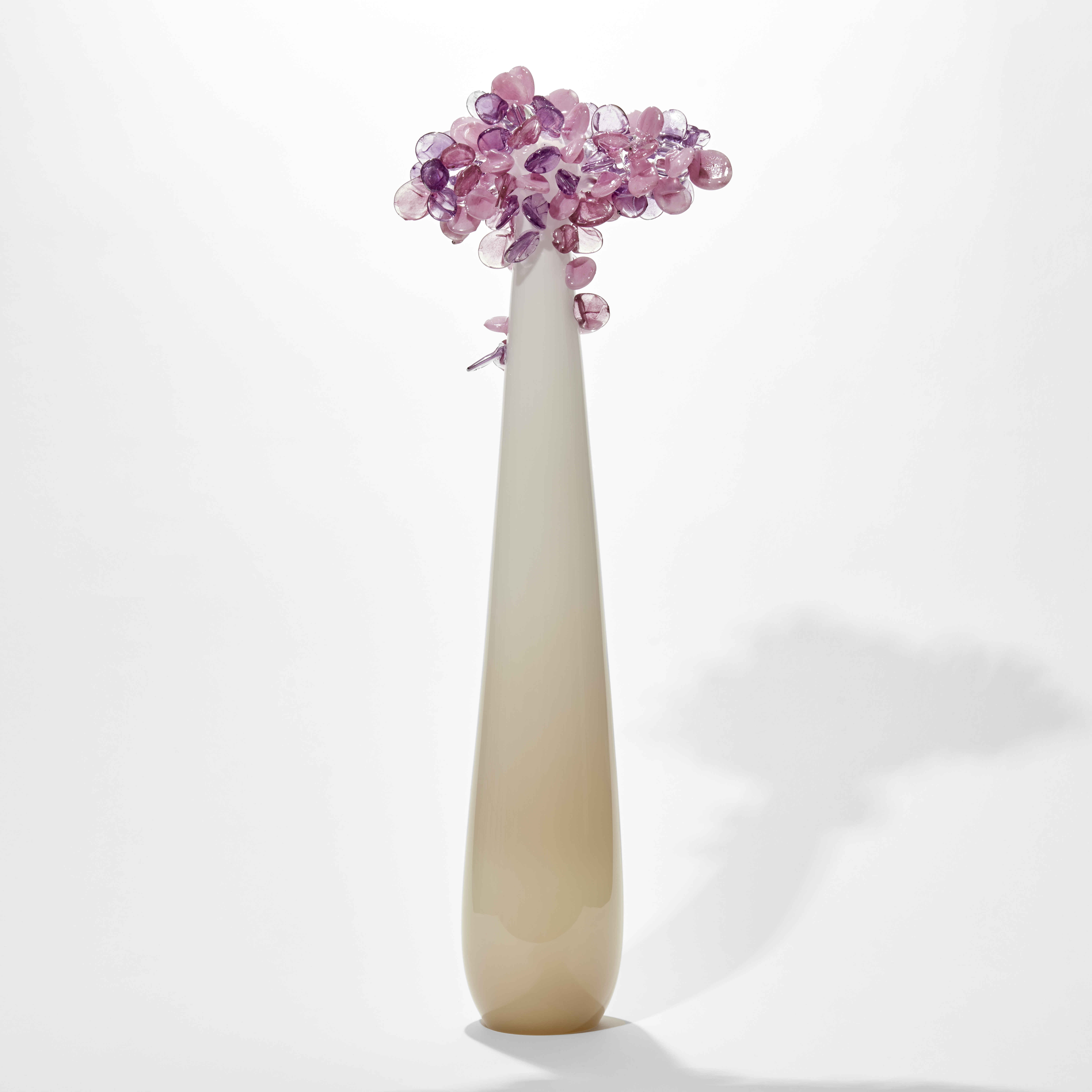 tall and thin simplified tree sculpture with smooth beige and cream trunk with candy pop rounded lollipop leaves clustered at the top hand made from glass