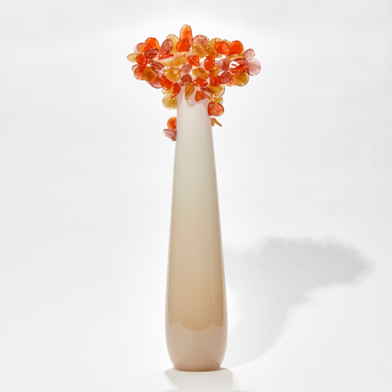 tall cream beige and orange simplified tree sculpture with a smooth column trunk and cluster of lollipop like leaves covering the top