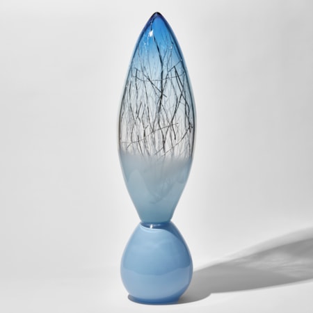 pale baby blue and aquamarine tall glass sculpture with rounded base and pointed oval top with thin white and silver glass canes trapped inside