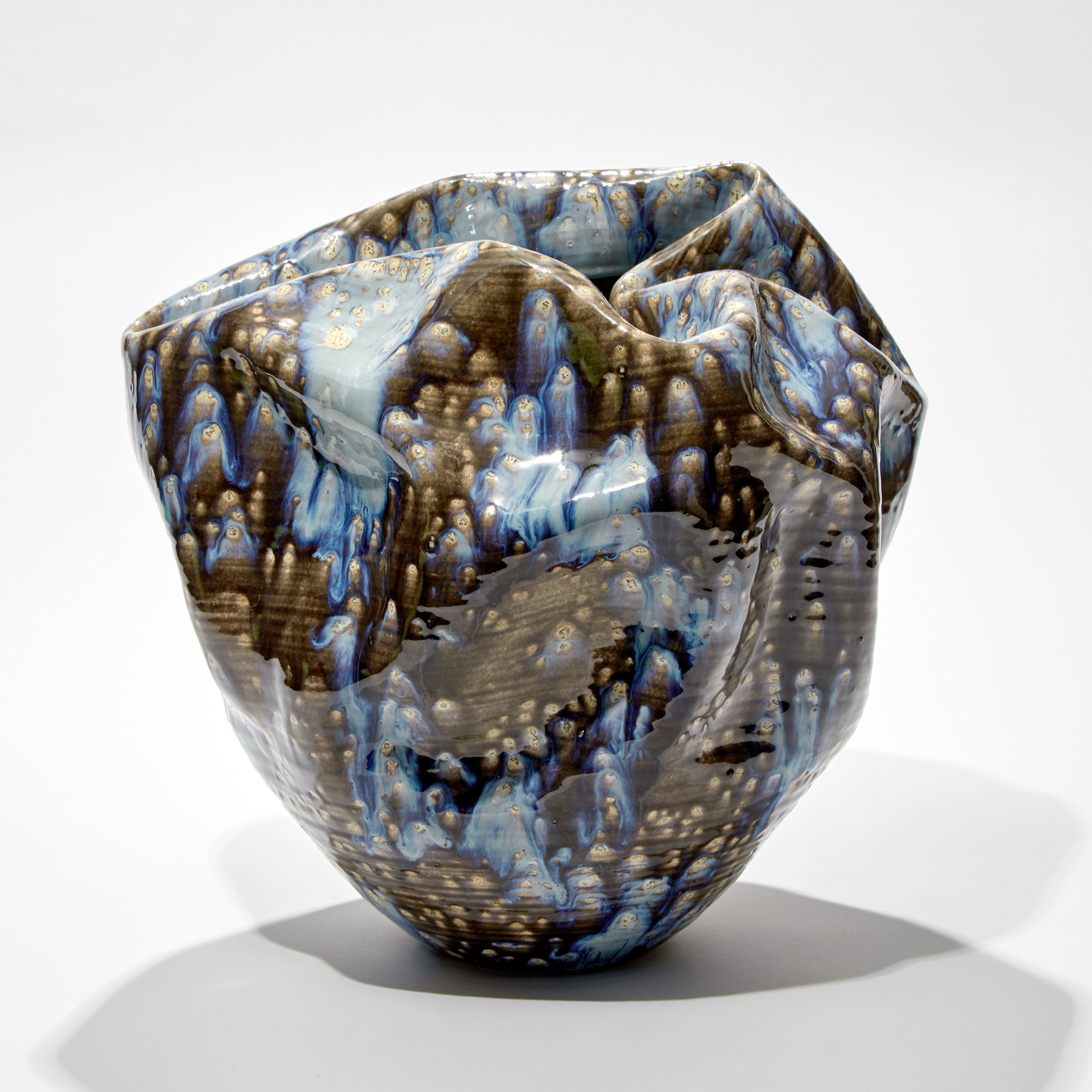 crumpled formed vessel with blue grey and white speckled smeared and running glaze hand made from ceramic