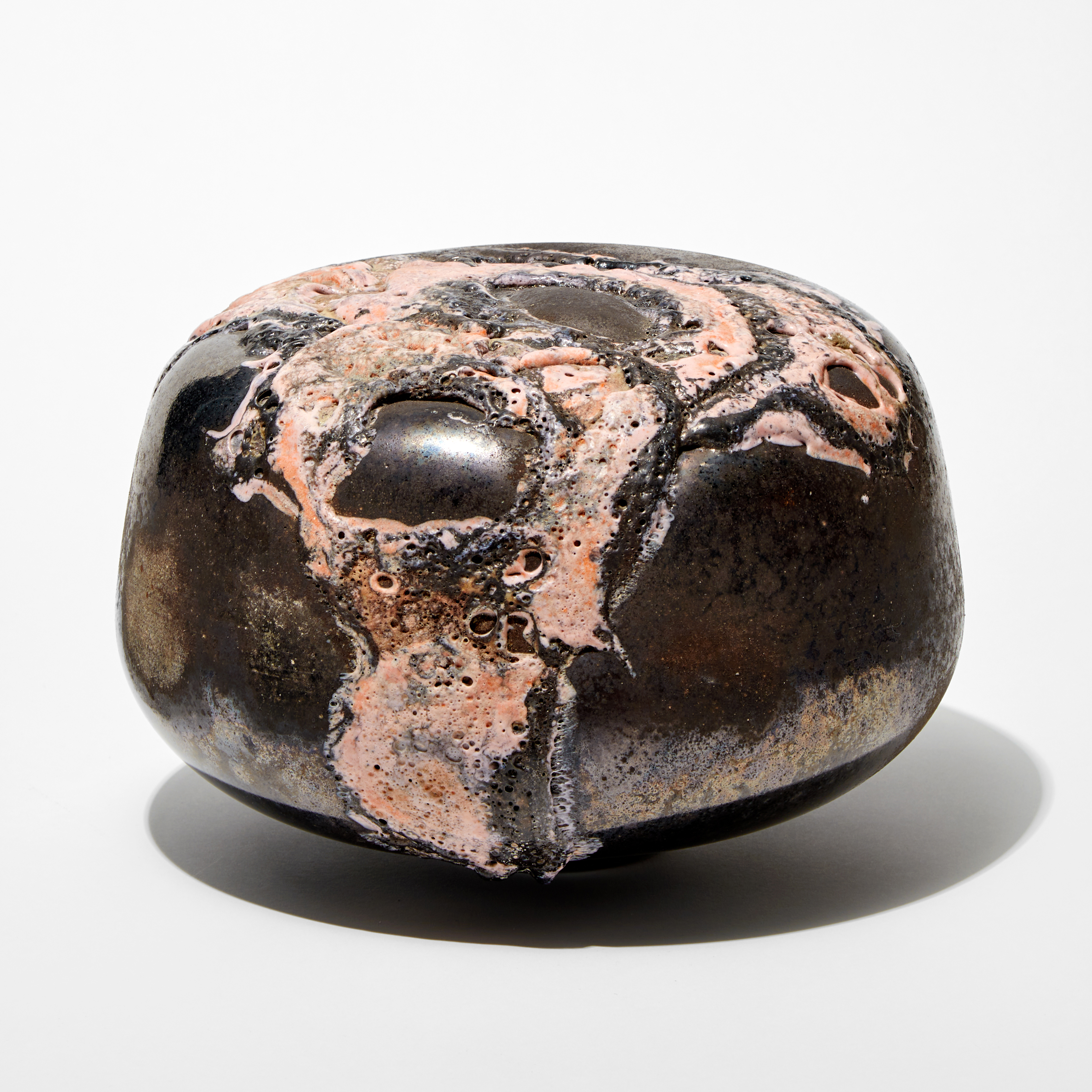 round low solid mushroom form sculpture with metallic bronze finish and relief lava like detail pink hand made from glass