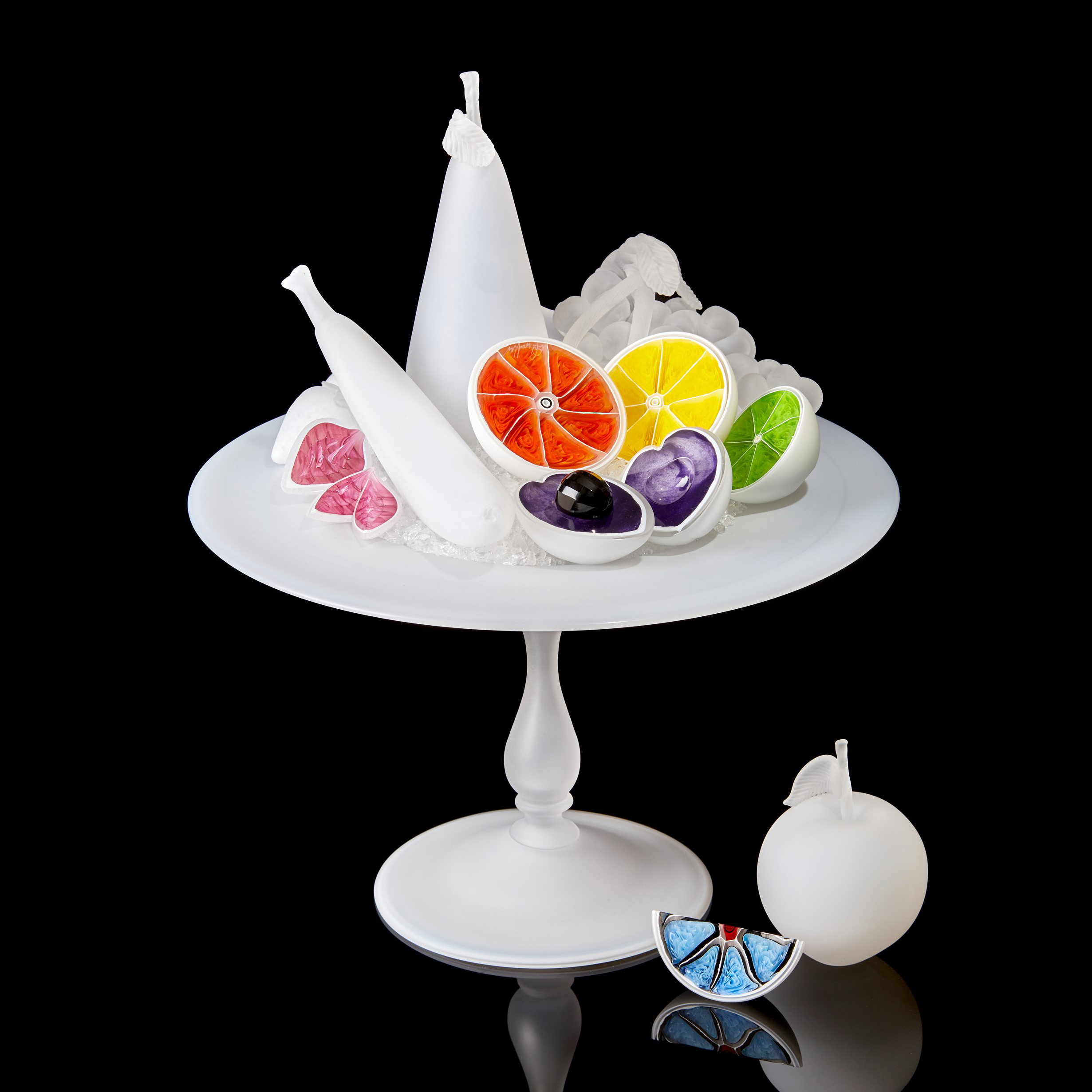 white centrepiece with bisected white fruits each with a different coloured interior handmade from glass