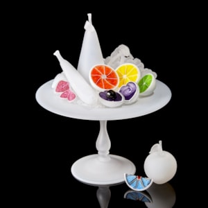 white centrepiece with bisected white fruits each with a different coloured interior handmade from glass