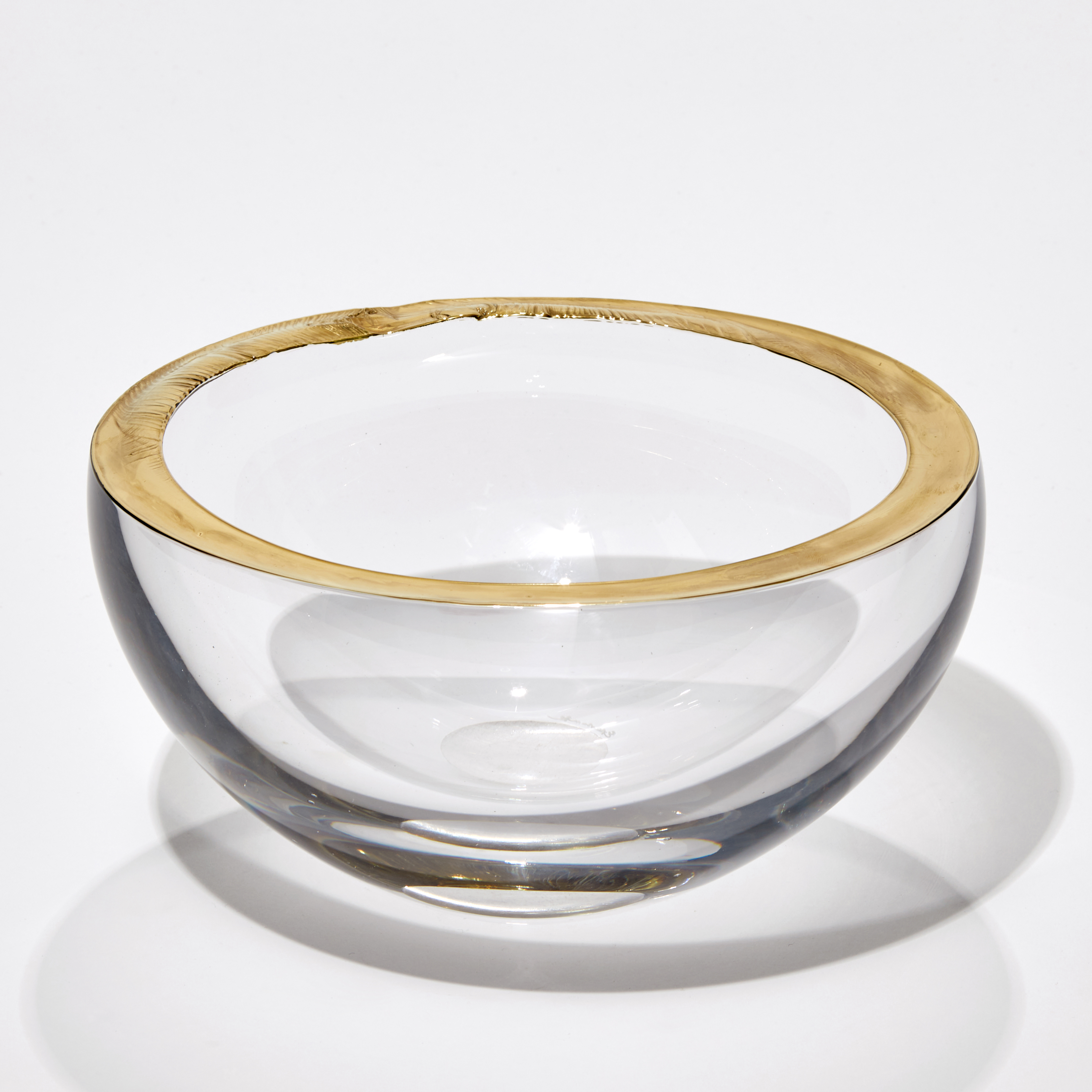 three modern art glass bowls in clear glass with gold or platinum rims
