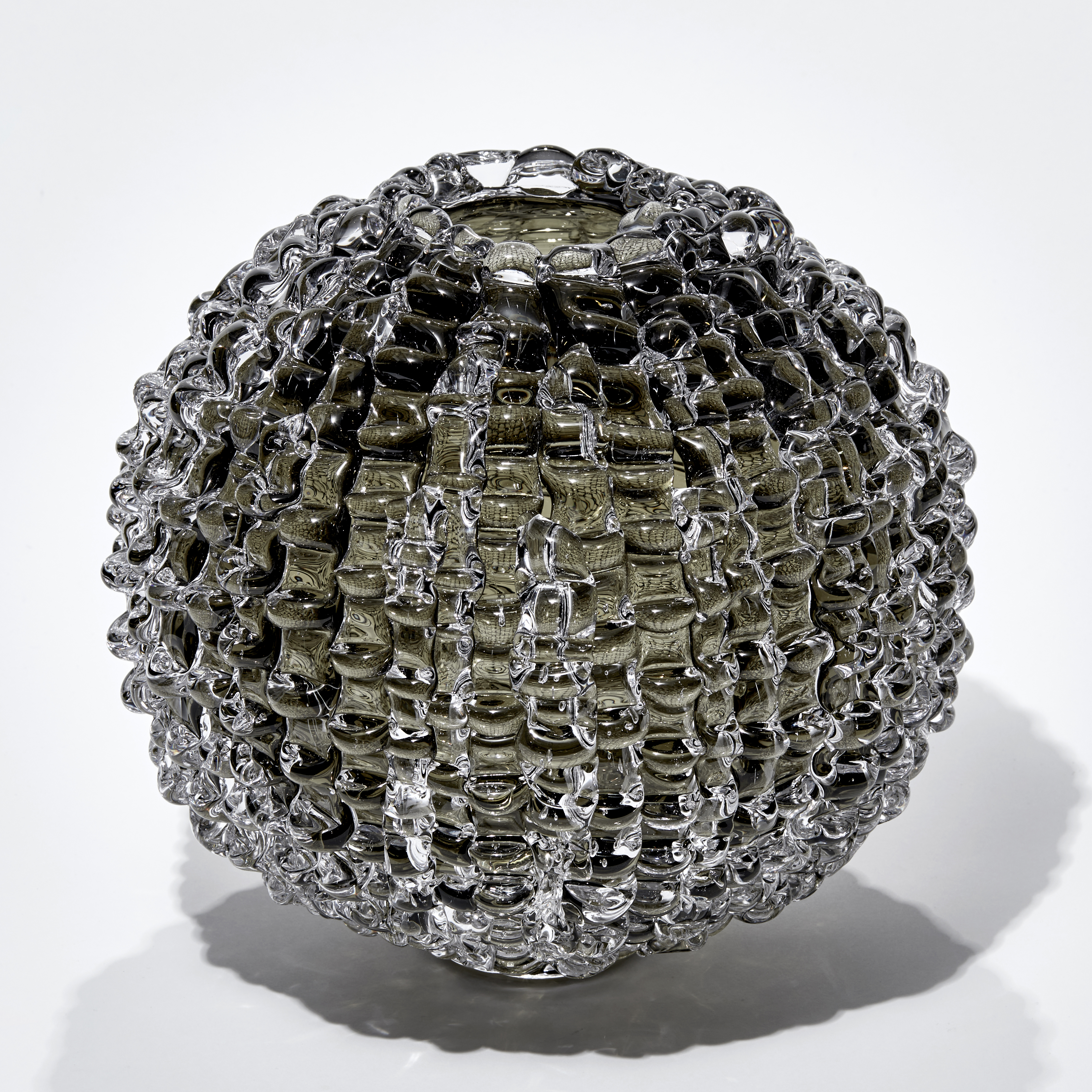 urchin inspired round handmade glass sculpture in bronze grey colour with undulating ridged surface