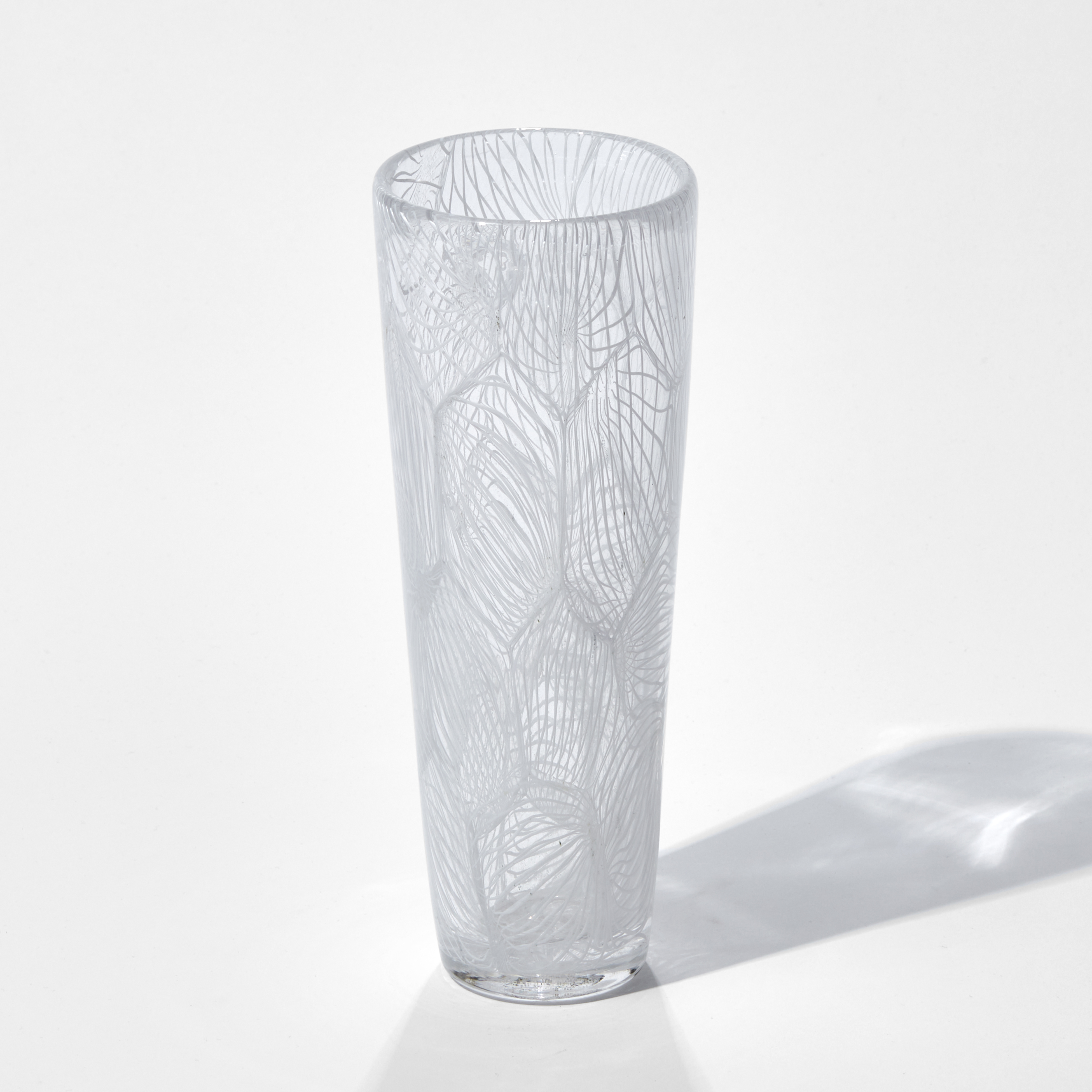 tall clear glass sculpture with external white pattern