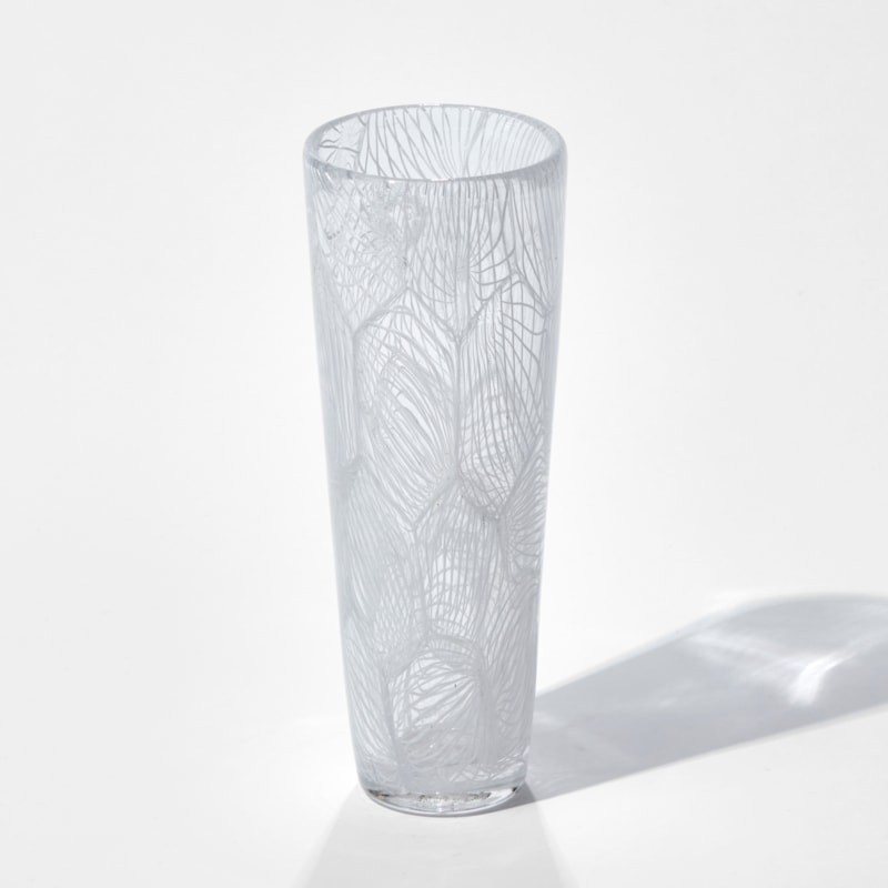 tall clear glass sculpture with external white pattern