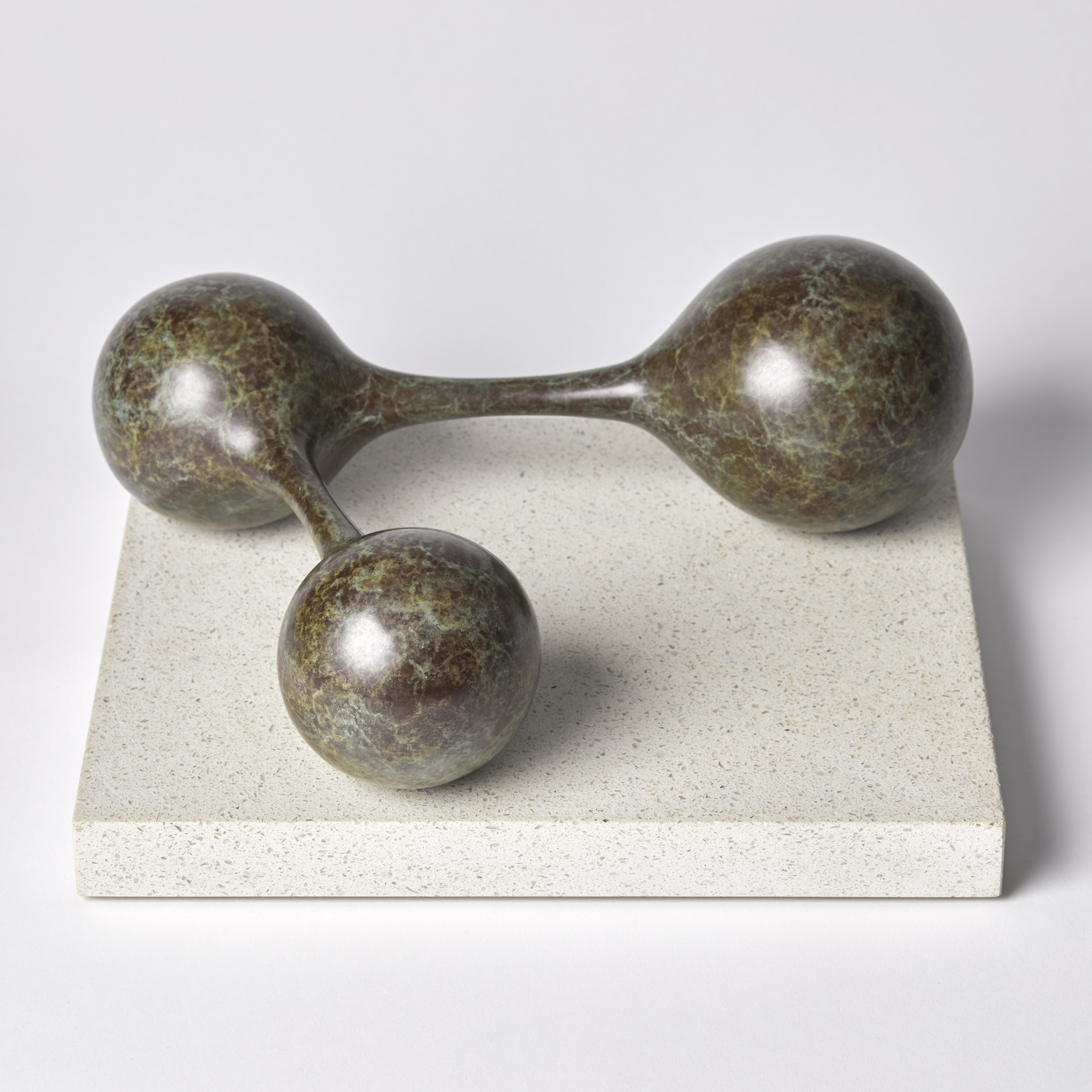 bronze minimalist sculpture of connected spheres on limestone base
