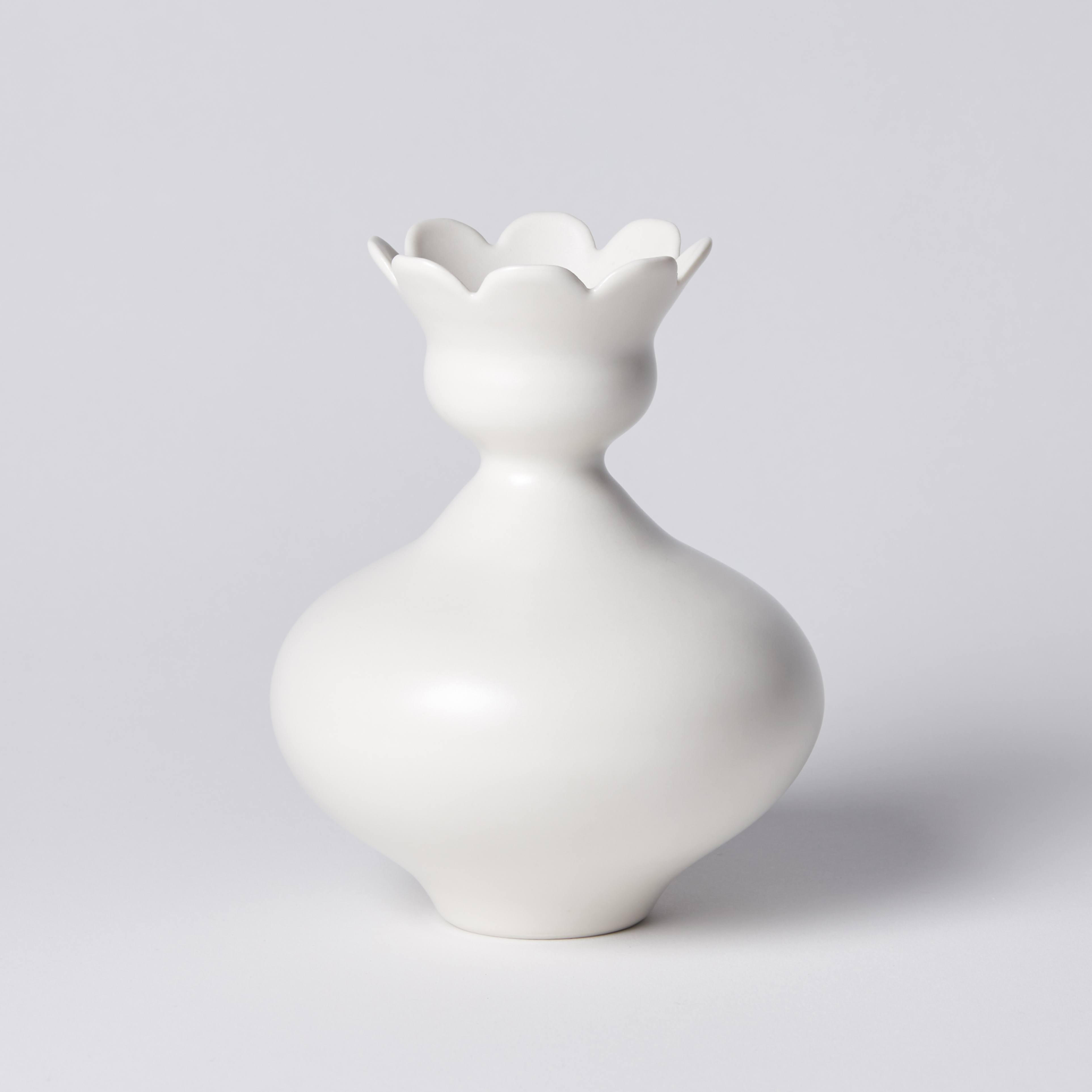 white squat rounded vase with flower shaped opening with eight petals hand made from porcelain