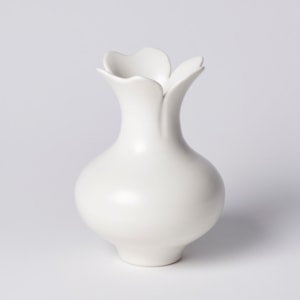 short white rounded vase with narrowing neck and flared opening branching in to three petals hand made from porcelain