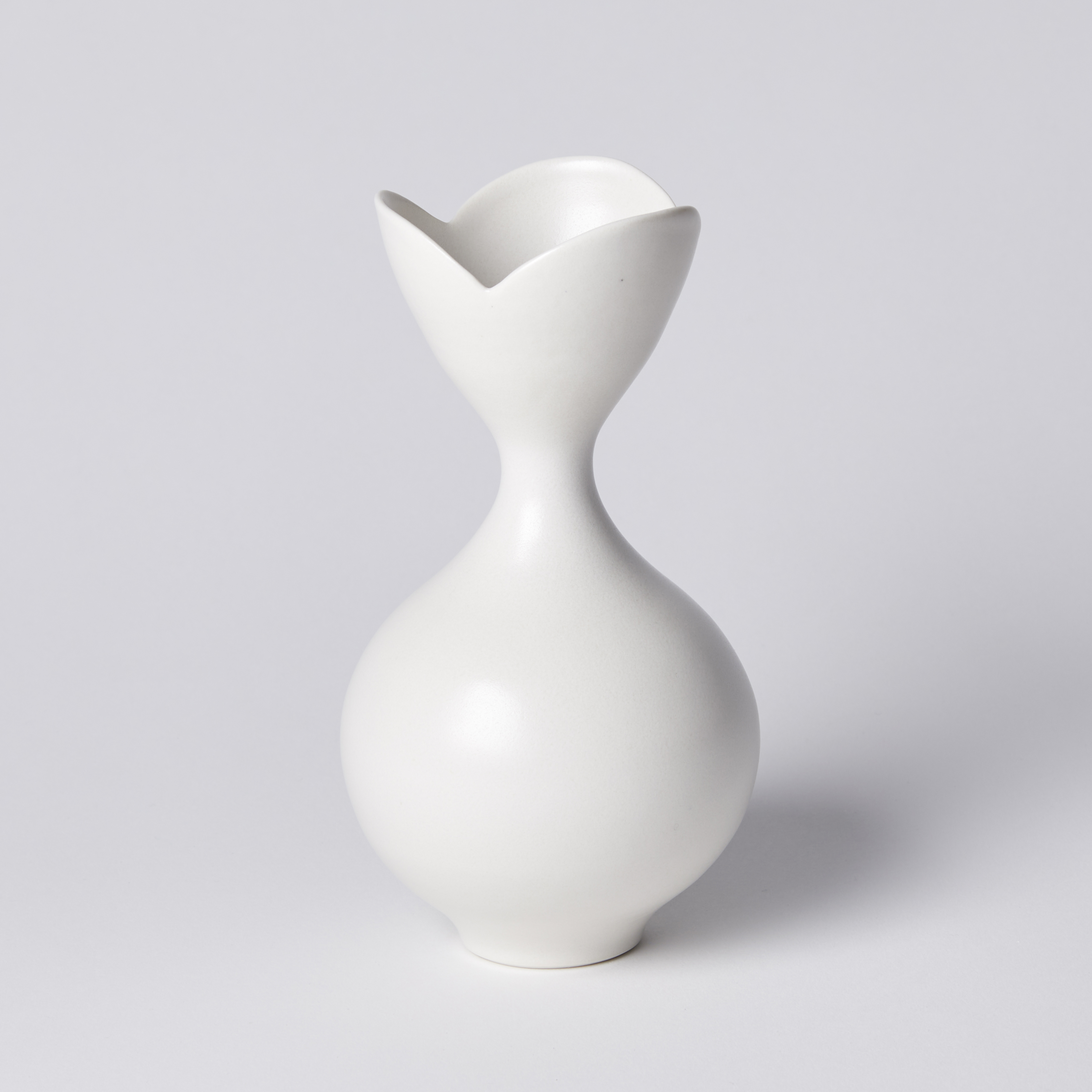 white classically shaped vase with flower shaped opening with three petals hand made from porcelain