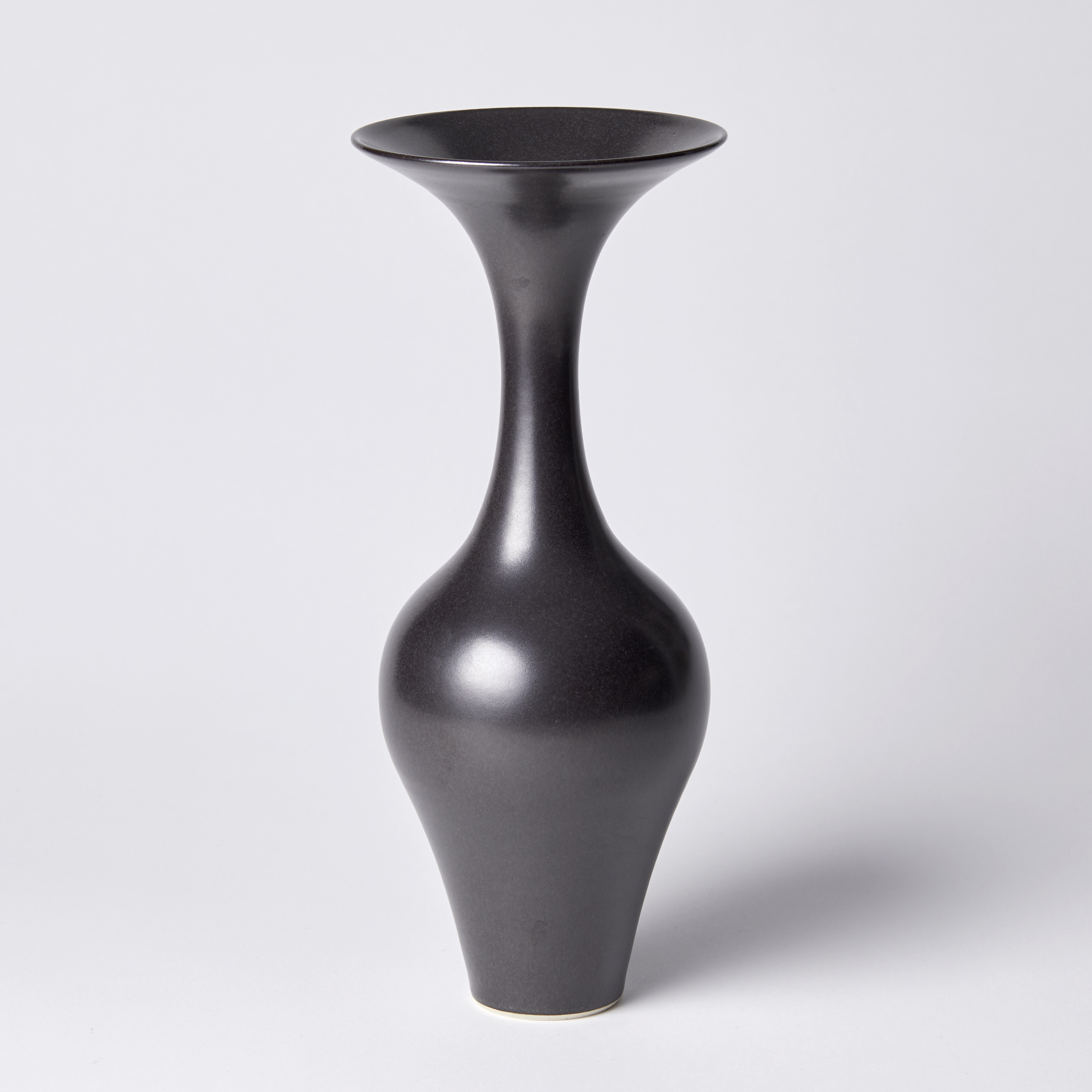 black classical shaped vase with long neck and flared rim hand thrown from porcelain and glazed a dark ebony brown