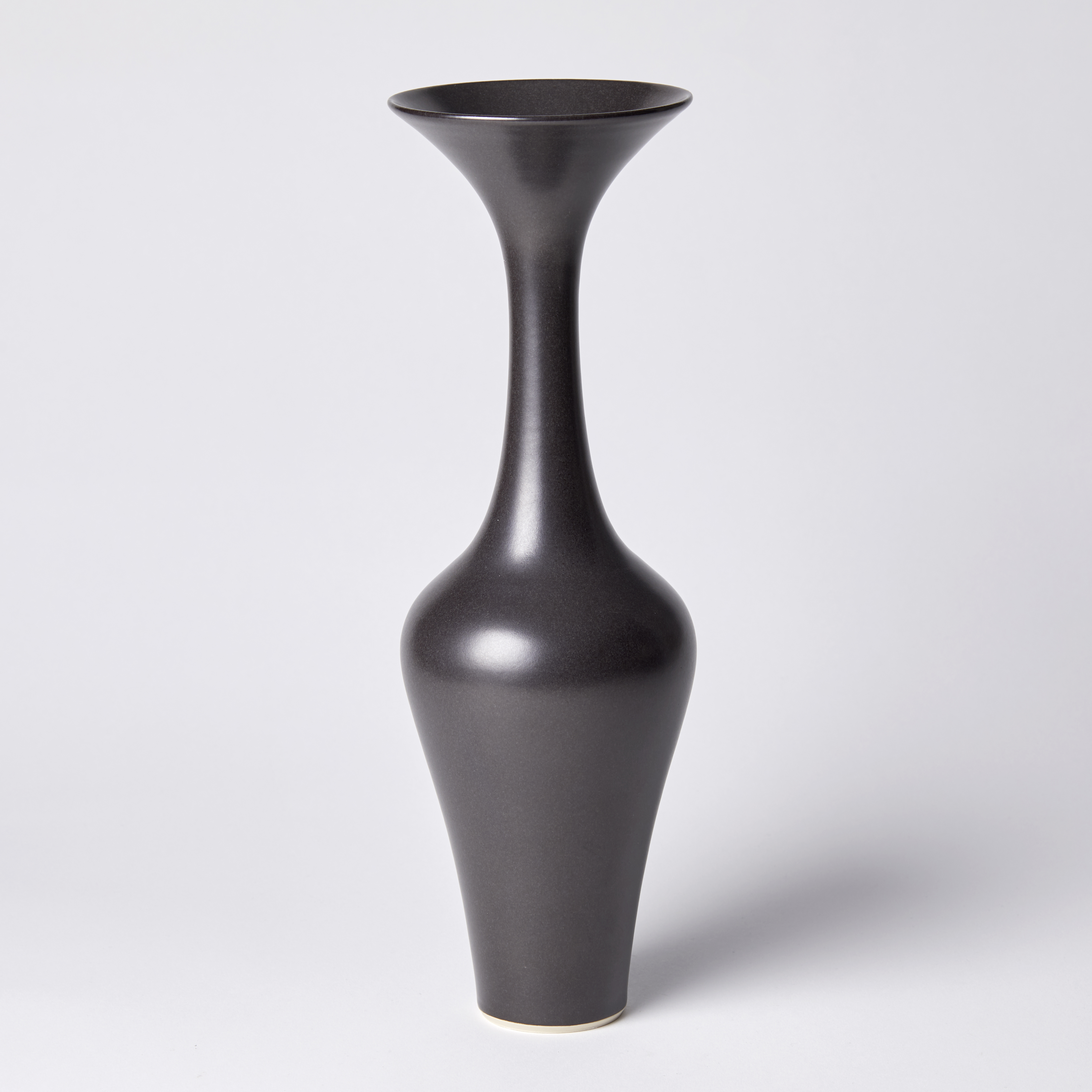 tall slender classical vase with graceful curves long slim neck and flared trumpet shaped rim hand thrown from porcelain and glazed ebony black brown