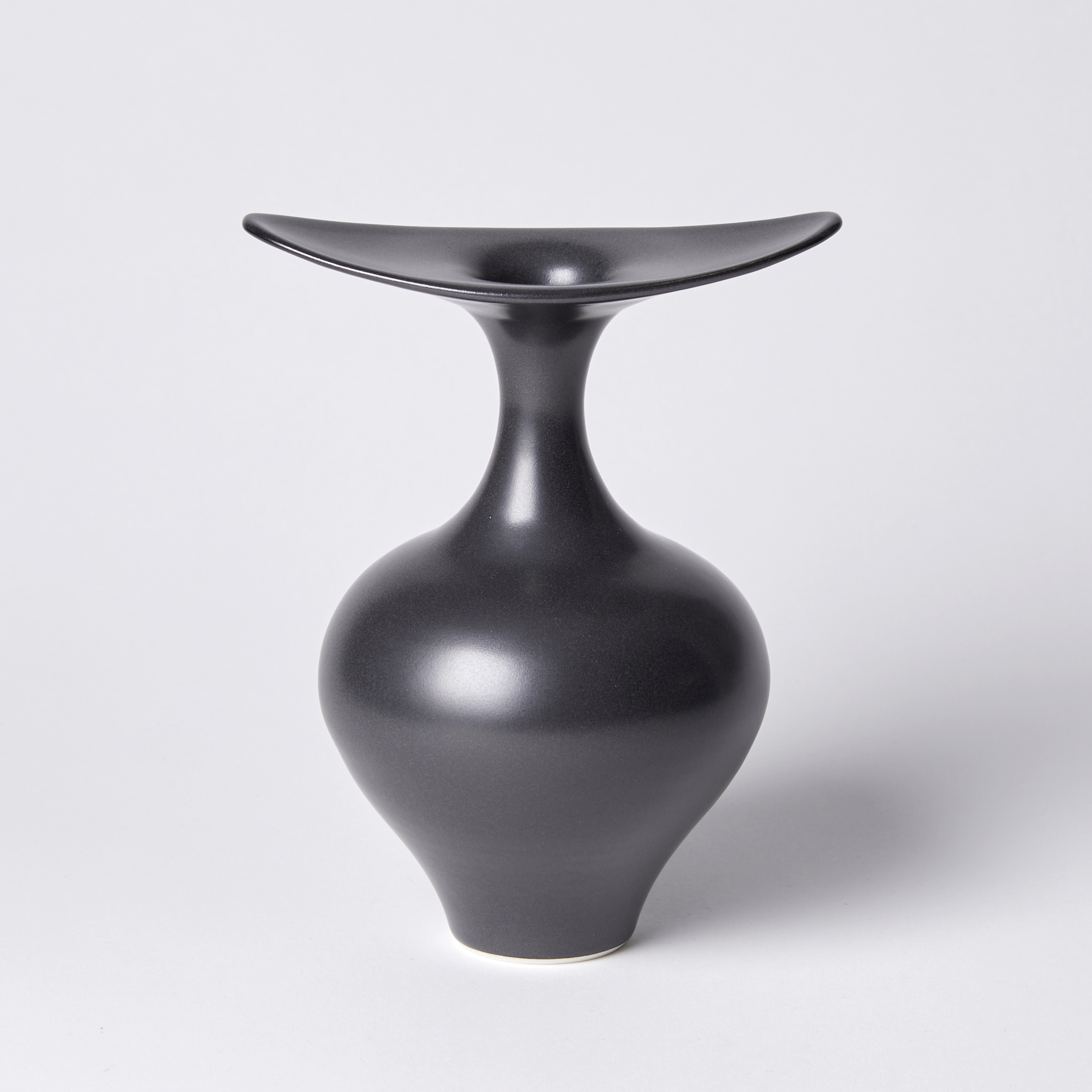 classically shaped base black vase with finned flared opening spanning in two directions hand made from porcelain