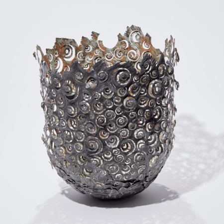 dark brown and copper aged looking large metal vessel with hand cut organic ammonite swirling patter and irregular top edge