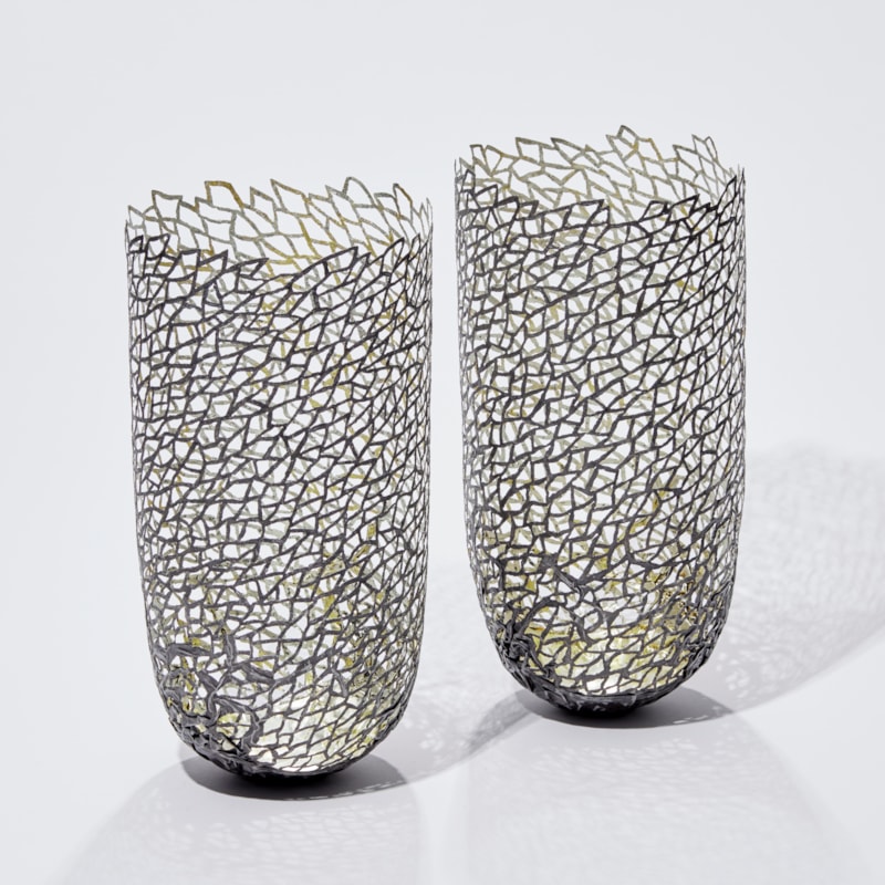 two modern art sculpted vessels made from steel and gold