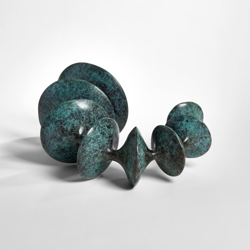 sculpted bronze artwork of circular forms linked by thread