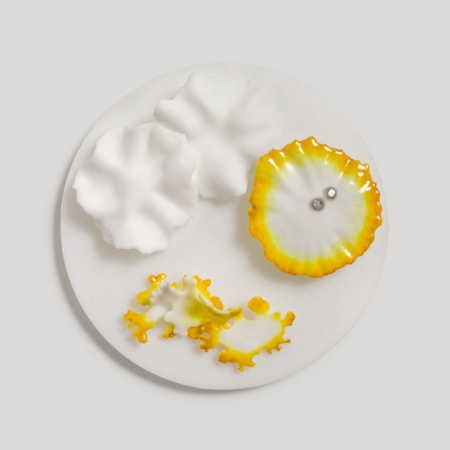 white disc with organic frilled floral raised detail in white amber yellow and silver handmade from glass