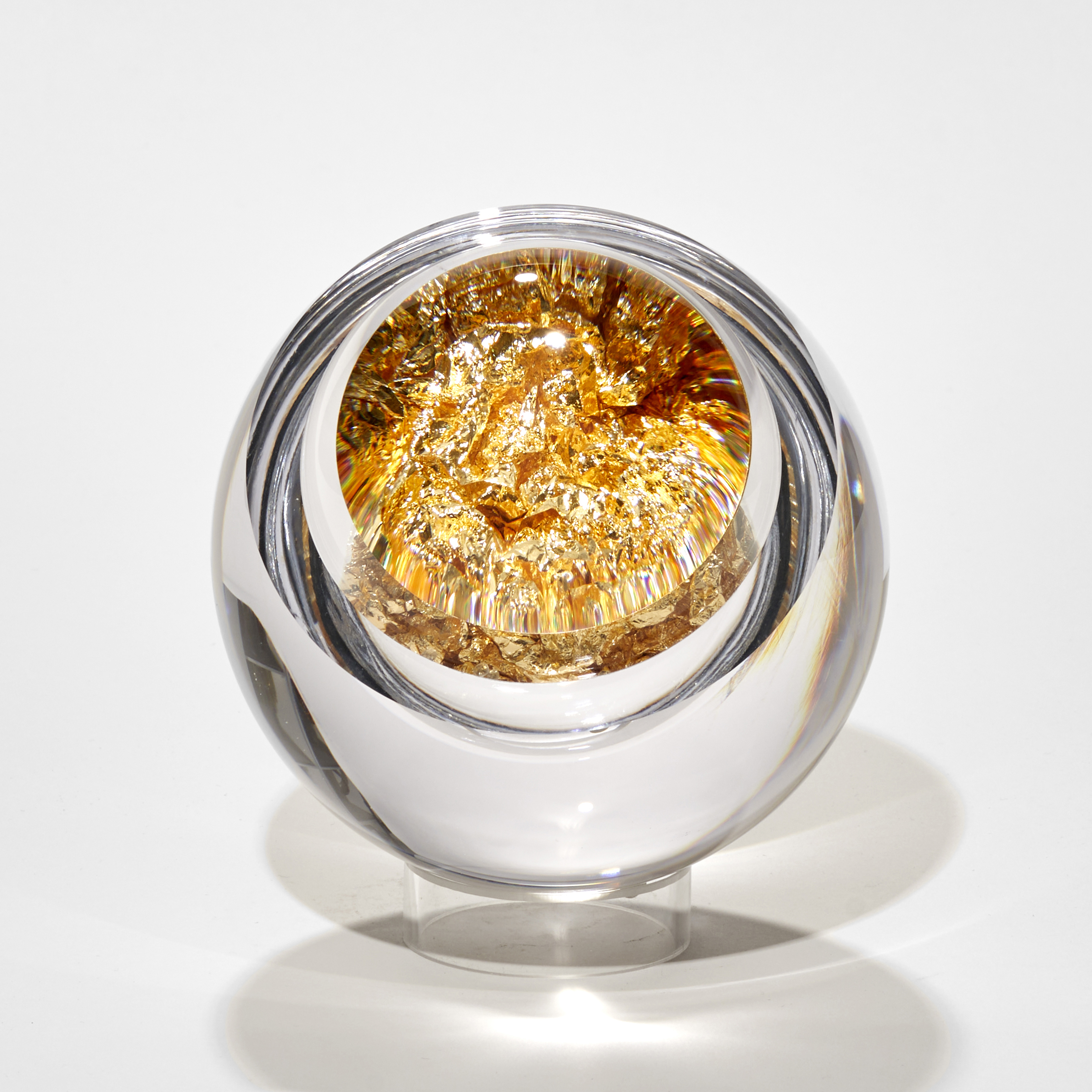 clear round ball with interior filled with gold with lens lid enhancing the contents handmade from glass