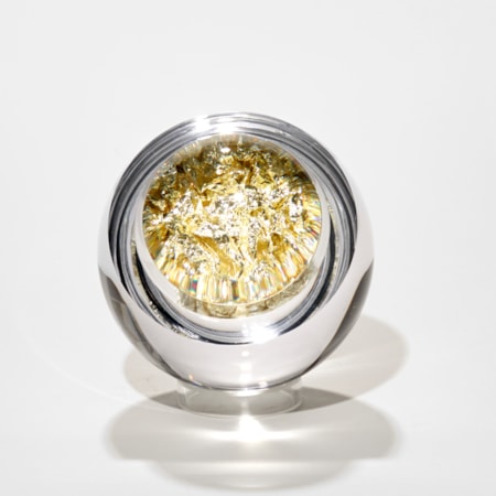 clear round glass mass with interior filled with pale gold leaf crushed to fill the void with lens lid magnifying the contents hand made