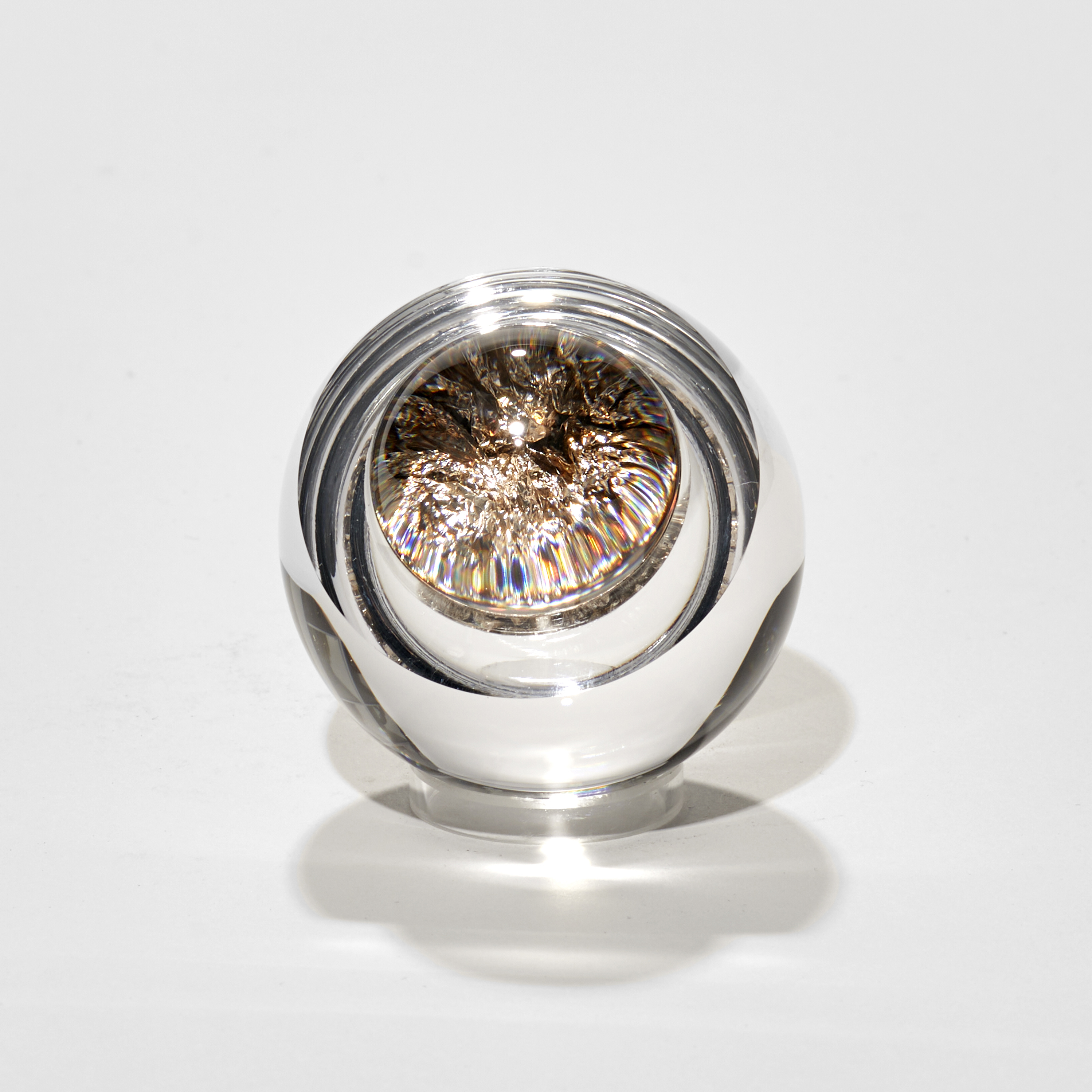 small clear glass round object filled with crushed champagne gold leaf handmade from glass