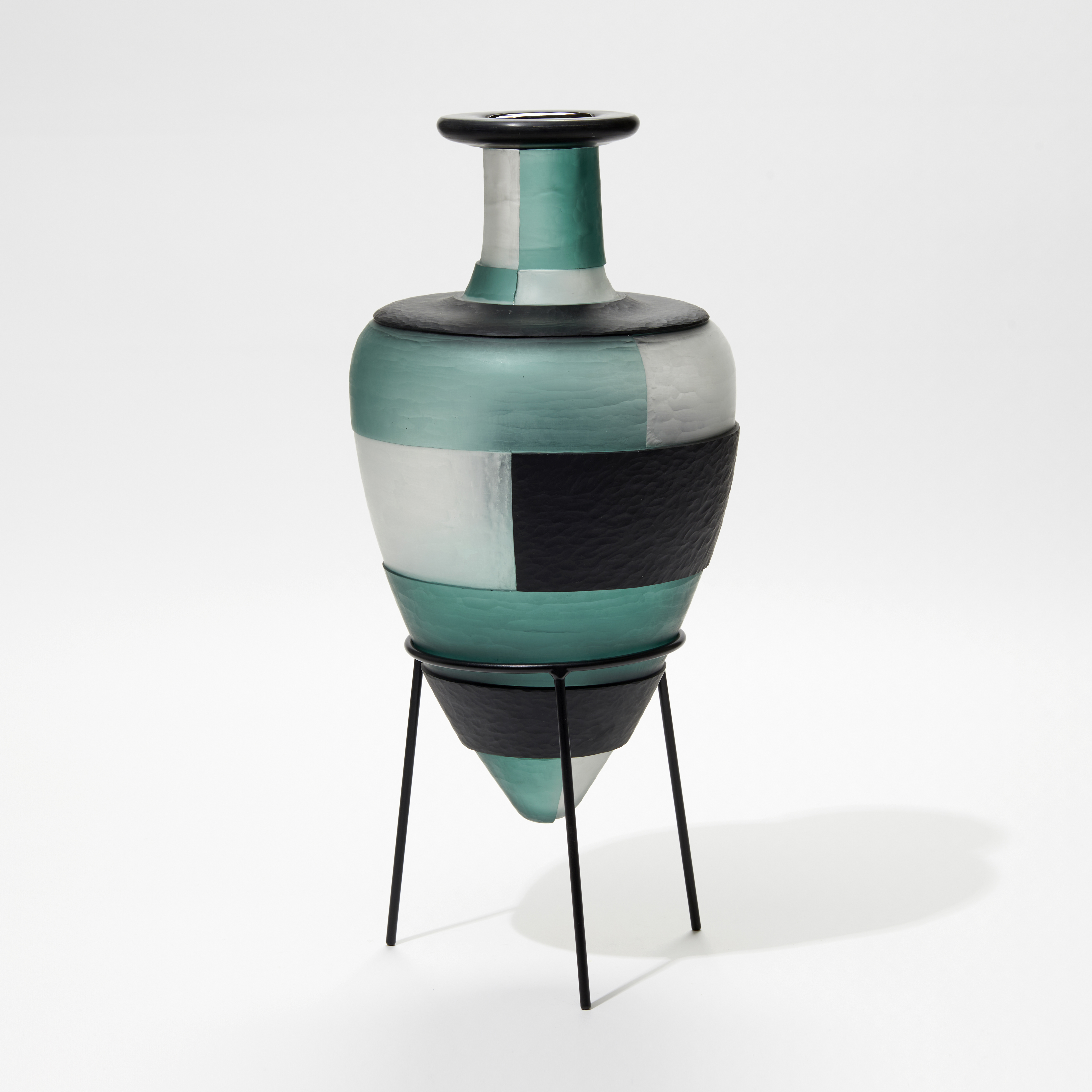 jade clear and dark forest green amphora glass bottles with textured surface and block pattern perched in a tripod black steel base