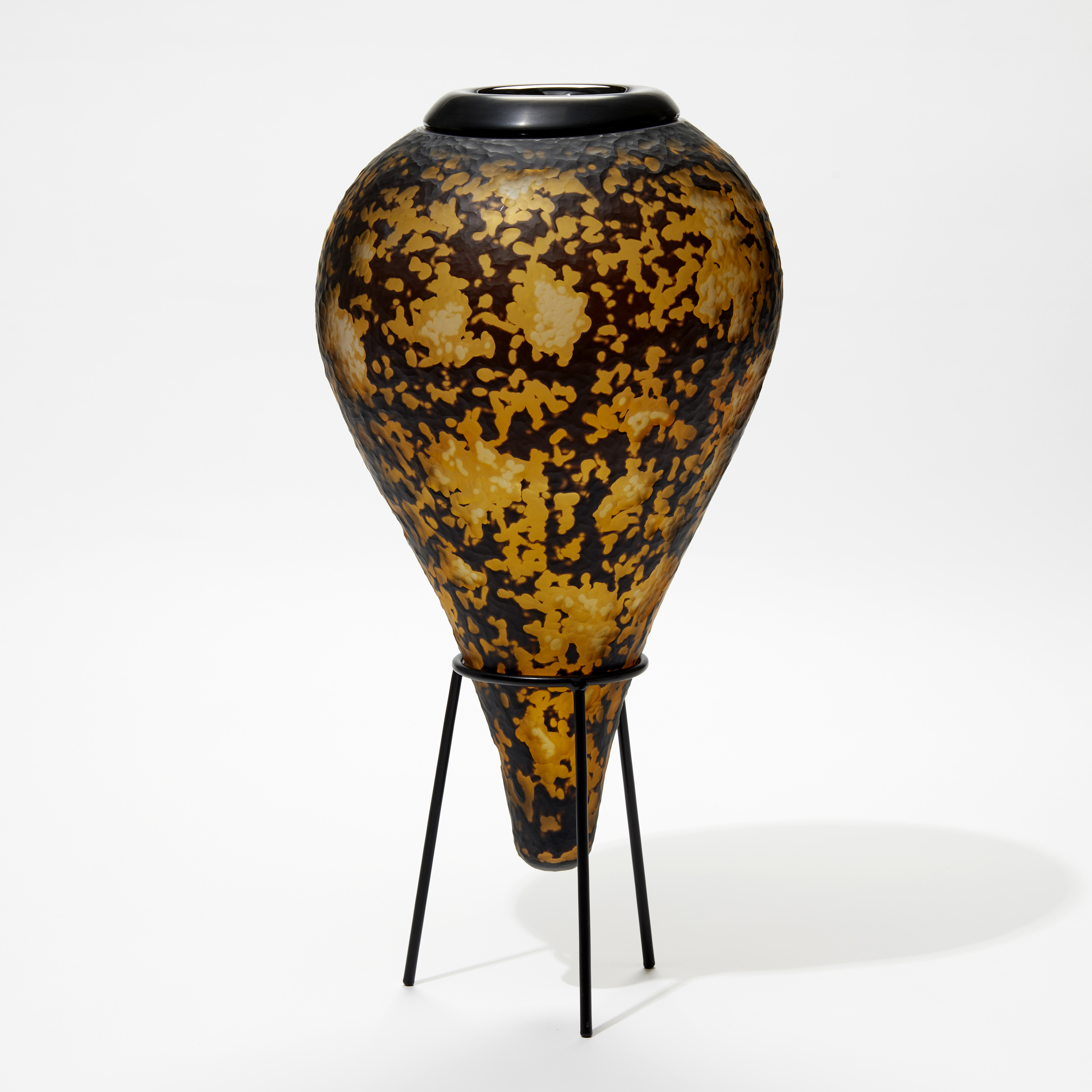 amber and black organic textured amphora bottle with black cuff opening and black steel stand