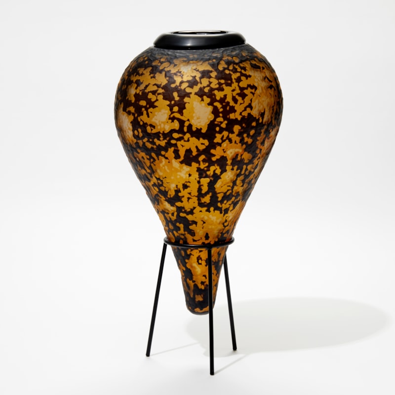 amber and black organic textured amphora bottle with black cuff opening and black steel stand