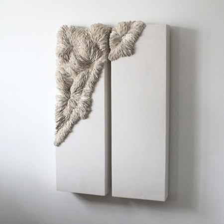 twinned large long rectangular wall mounted light grey stone like sections with organic raised shard detail in the two left corners moving from one panel to the next hand made from porcelain and tadelakt plaster