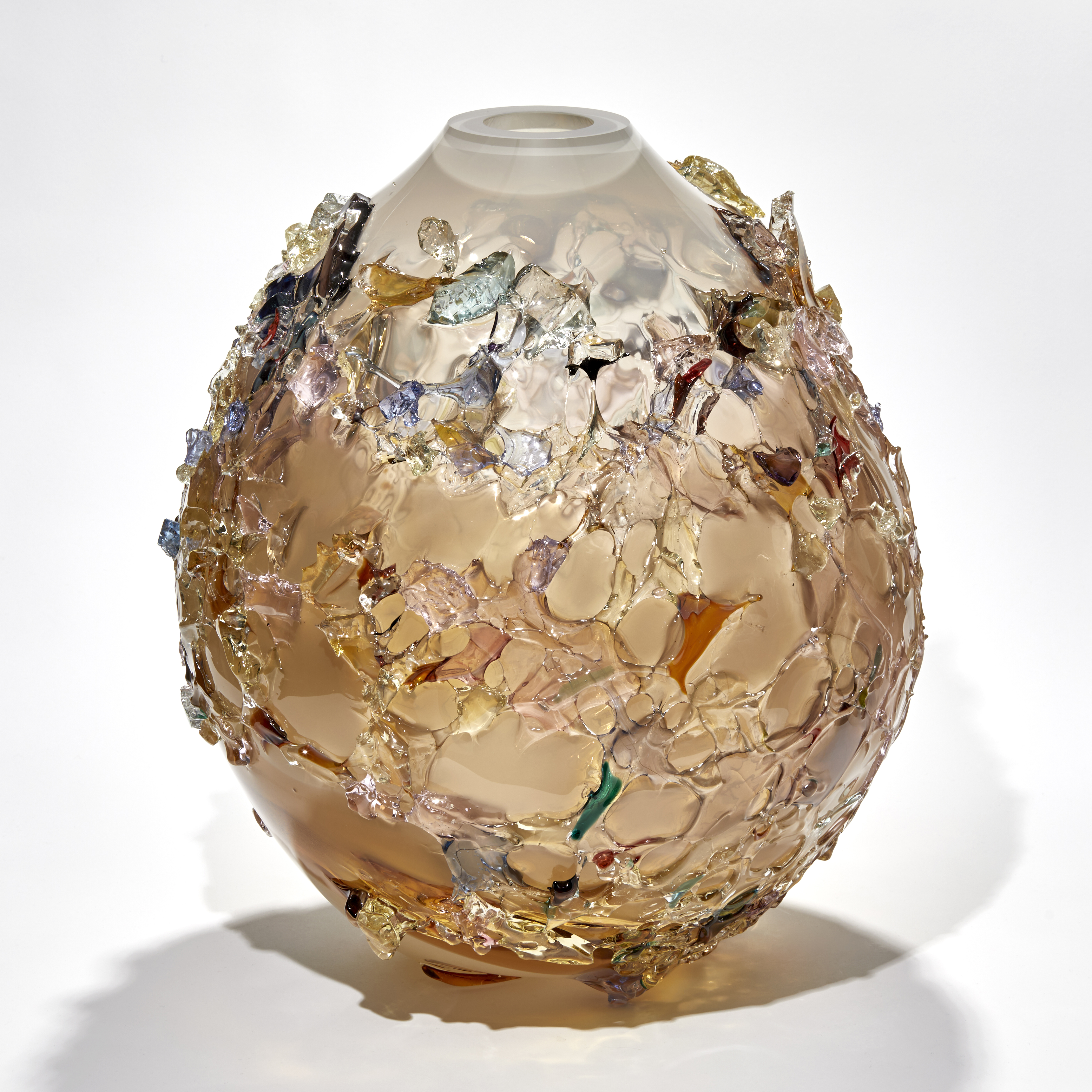 squat rounded teardrop shaped vase in soft peach and white with raised organic texture over the surface in various colours handmade from glass