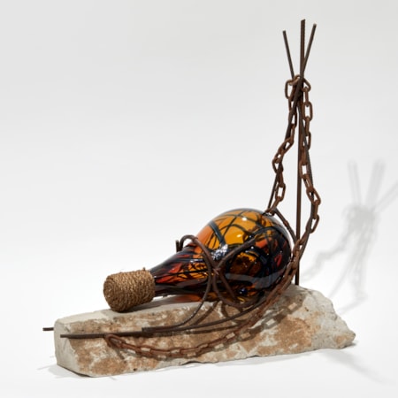 tipped amber glass amphora bottle chained to a base of solid stone handmade sculpture
