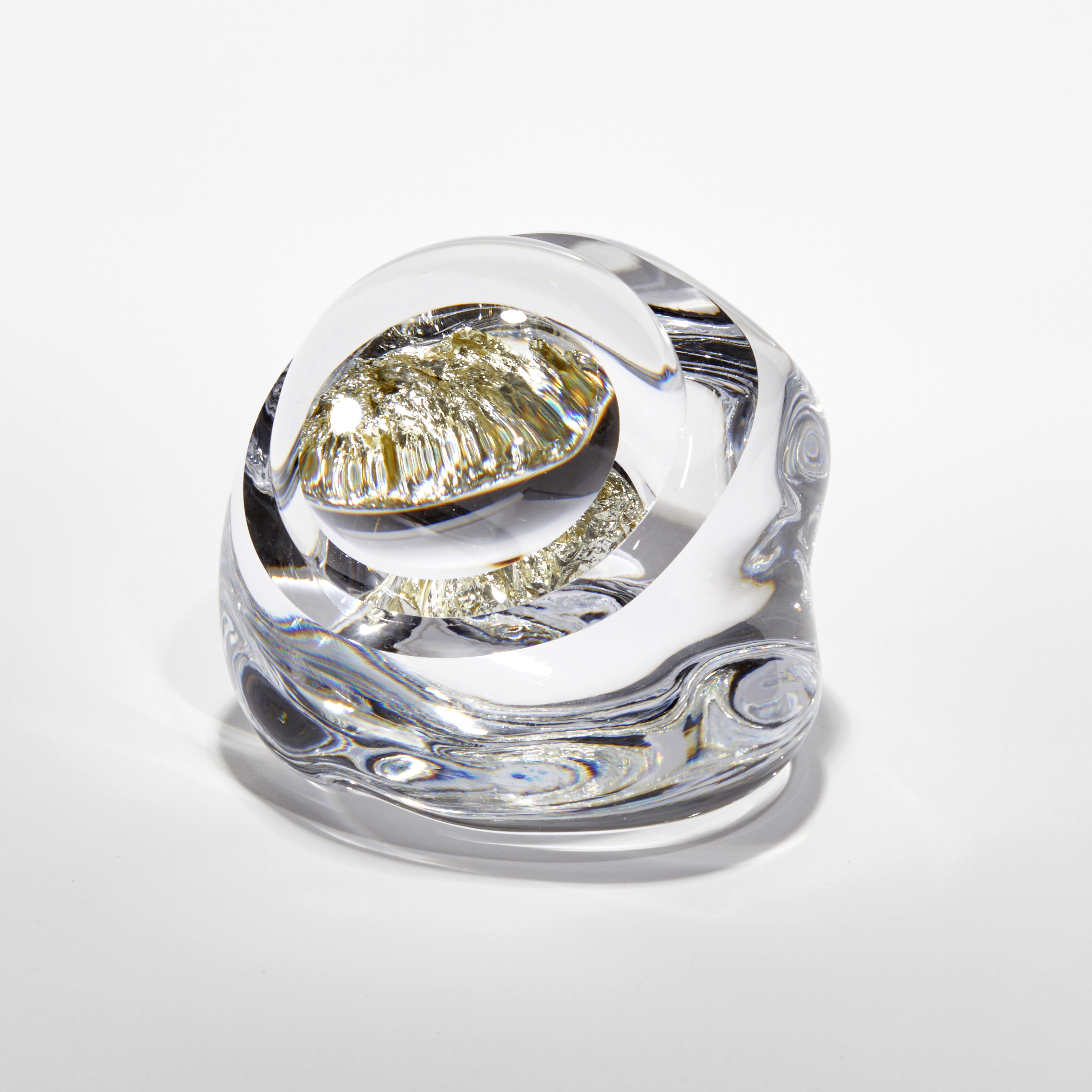 small clear smooth rock with interior filled with white gold hand blown and sculpted from glass