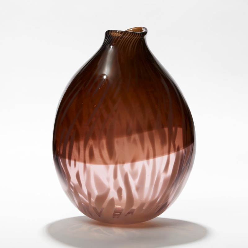rounded oval transparent vessel with bottom half in soft pink the top in sepia aubergine with an organic abstract feathered surface pattern hand made from glass