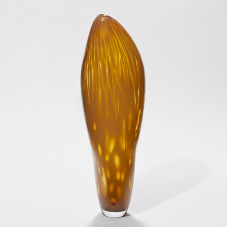 tall asymmetric vessel with gentle pointed top and small opening in rich dark mustard yellow with abstract soft surface patterns hand made from glass