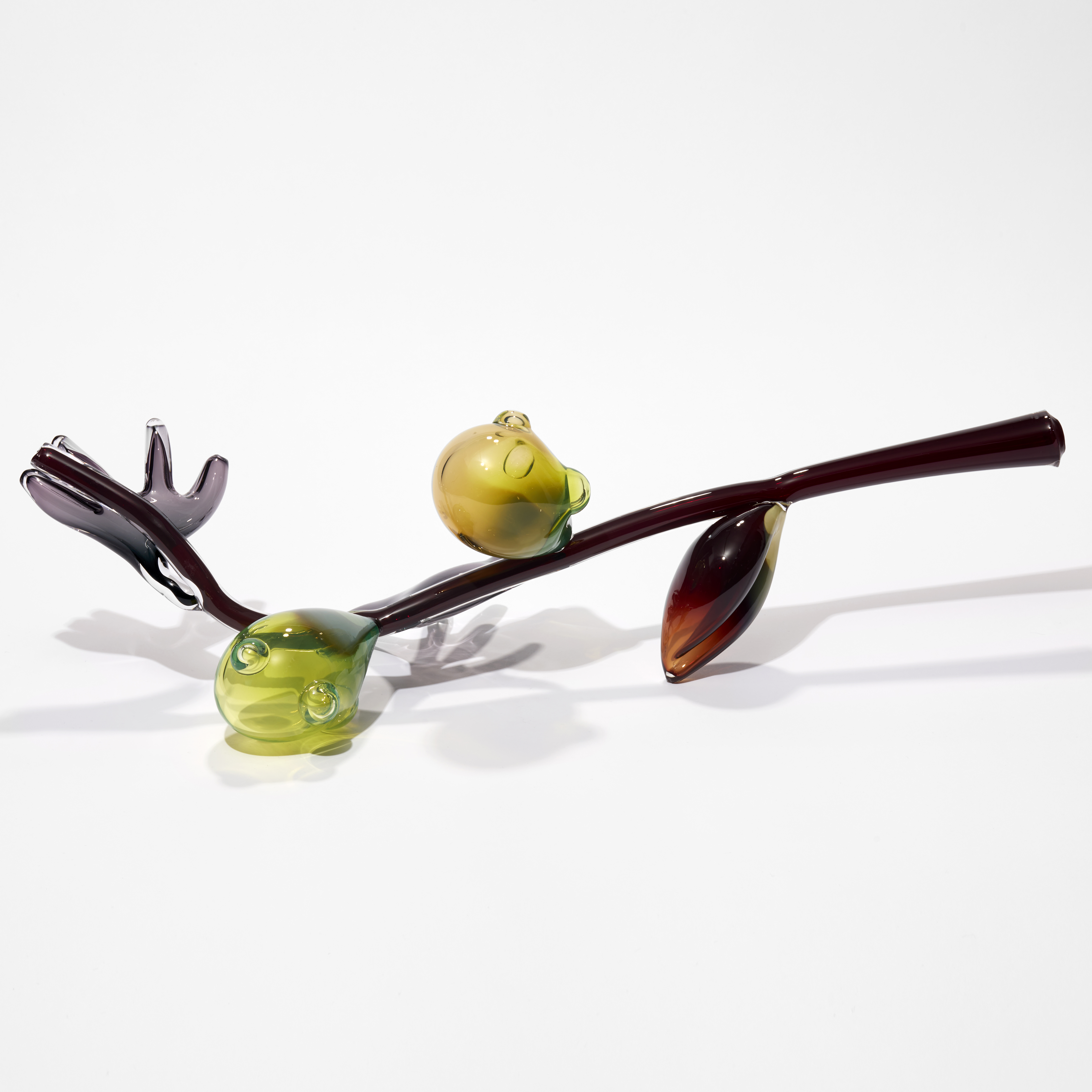abstract branch with fruits and leaves in brown yellow green and red hand sculpted from glass
