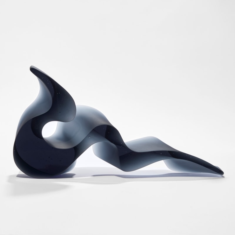 deep steel blue grey abstract simplified snake sculpture with fluid lines and two flat polished sides hand made from glass