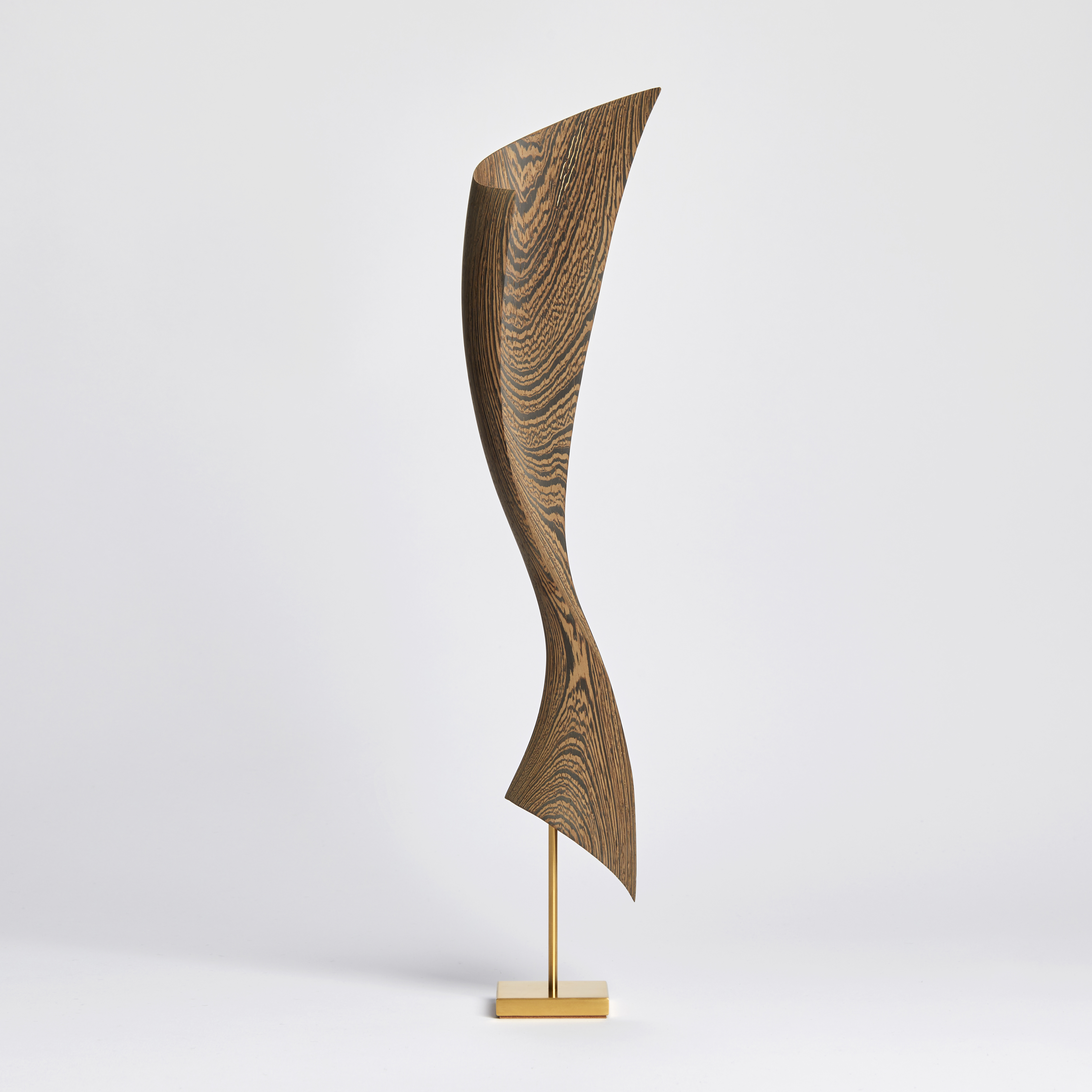 flared dynamic abstract wooden sculpture with gold inlaid in the grain perched on a gold plated stainless steel base