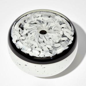 round low vessel with small central hole on the top in black and white with speckled base and mottled top hand made from glass