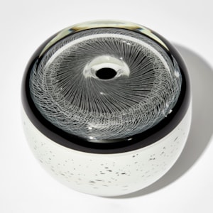monochrome artwork with spirograph style pattern on the top and white base speckled with black hand made from glass