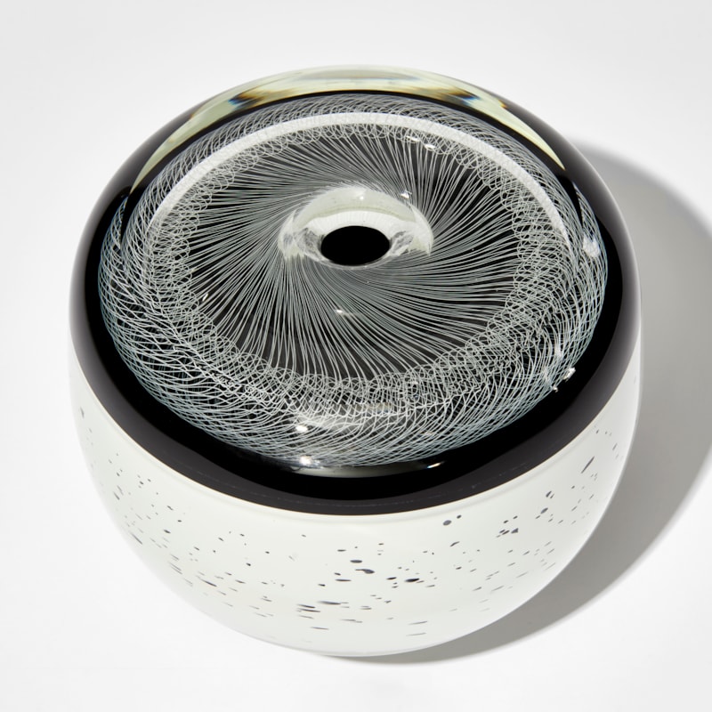 monochrome artwork with spirograph style pattern on the top and white base speckled with black hand made from glass